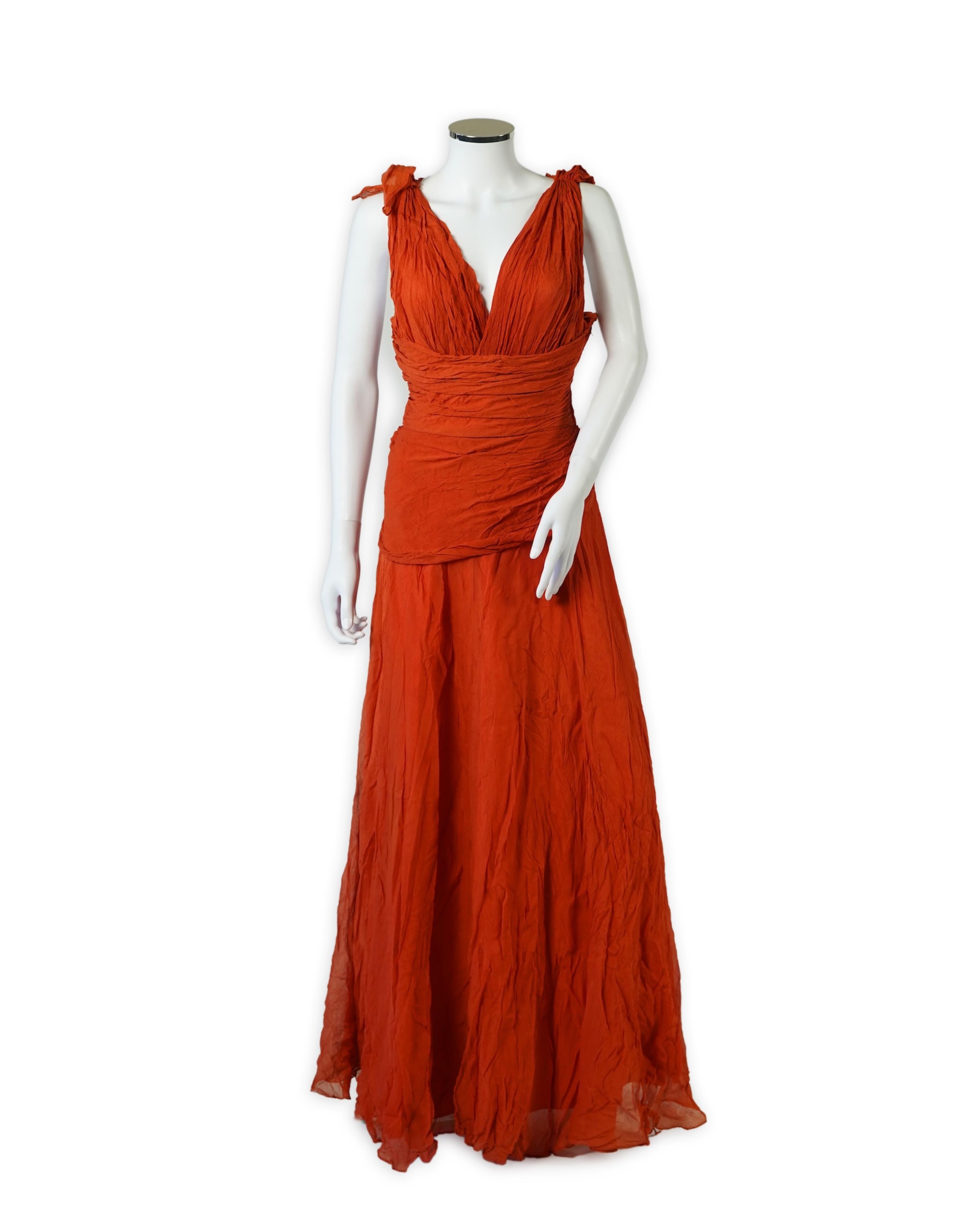 A 1940’s orange chiffon evening dress, with an orange silk taffeta lining, a pleated bodice and front apron panel tied at the back., 156 cm long. Condition - there are a few small holes in the chiffon at the back of the